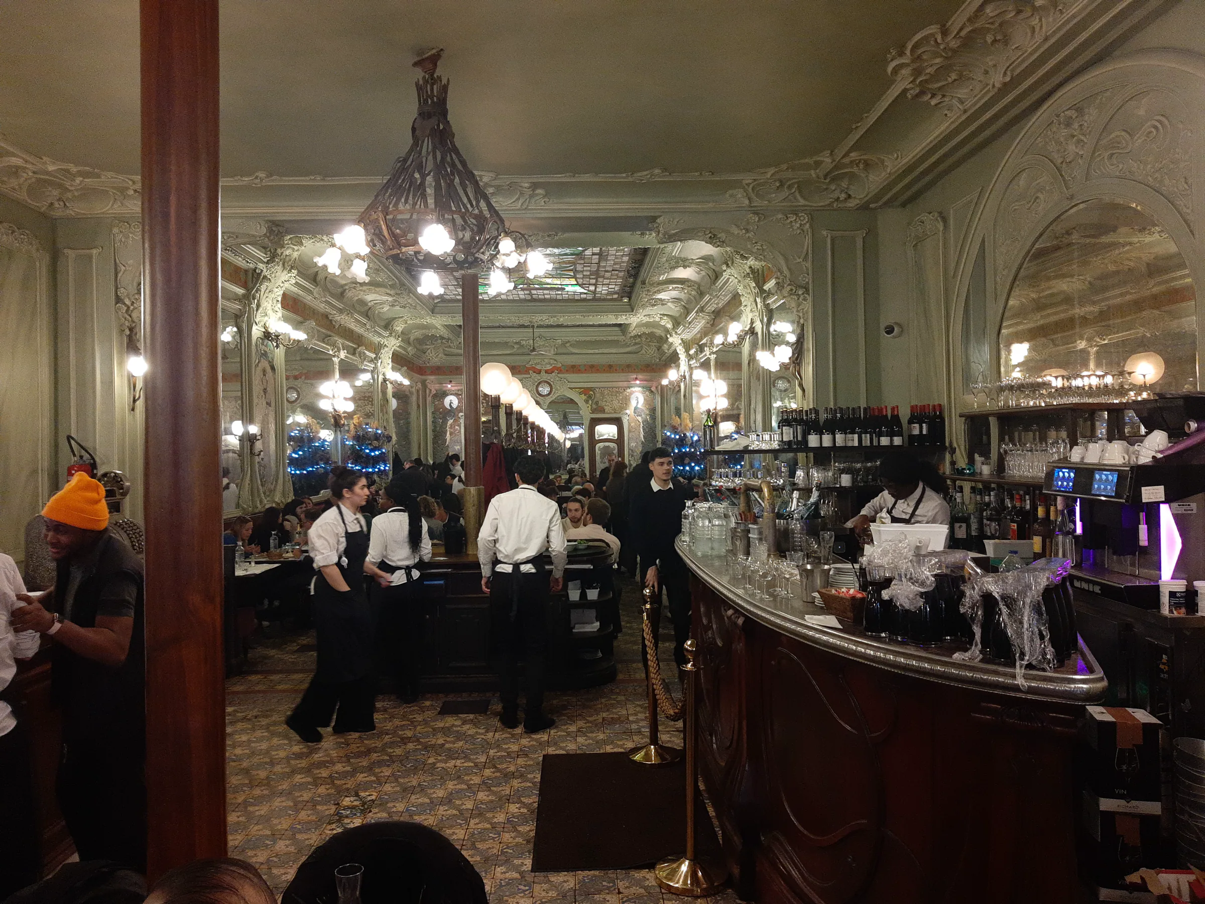 Servicepersonal in einer großen Brasserie mit Kronleuchtern